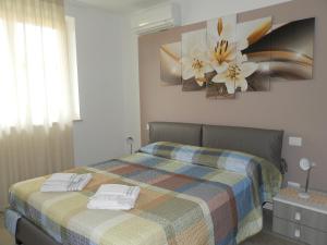 una camera da letto con un letto e un dipinto a fiori sul muro di Appartamenti Rossini a Bardolino