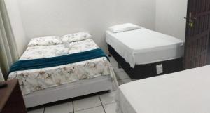 two beds in a small room with two mattresses at Hotel Ferrari in Lucas do Rio Verde
