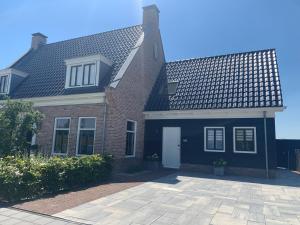 a large brick house with a blue roof at Logies Zen & Zilt Veere in Veere