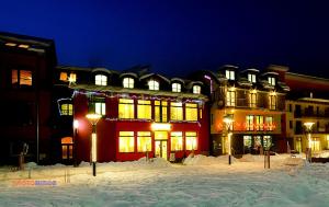 a building with snow in front of it at night at Penzion Kycera in Oščadnica