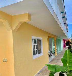 une maison jaune avec une fenêtre et des plantes dans l'établissement Casa Coral Cozumel, à Cozumel