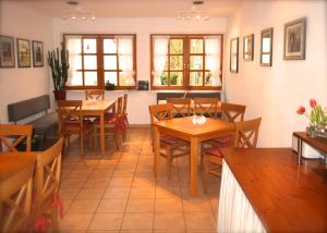 a restaurant with wooden tables and chairs and windows at Pension Kurhausblick in Bad Suderode