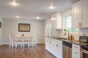 a kitchen with white cabinets and a table with chairs at Never Stop Exploring- 3 bedroom 2 bath home of duplex, close to Zion, Bryce, and Brianhead in Cedar City