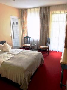 a hotel room with a bed and two chairs at Zur Kapelle in Kressbronn am Bodensee