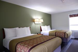 um quarto de hotel com duas camas e uma janela em Pine Motel em Deep River