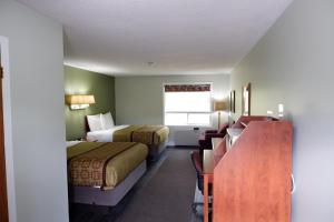 Habitación de hotel con 2 camas y escritorio en Pine Motel, en Deep River