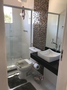 a bathroom with a toilet and a sink and a shower at Vivamar Ferradura in Búzios