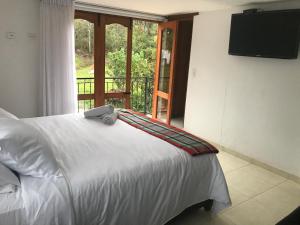 a bedroom with a bed with a television on the wall at Casa de Campo Villa Bonita hotel in Villa de Leyva