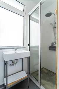 ein Bad mit einem Waschbecken und einem Spiegel in der Unterkunft Madeira Surf Camp in Porto da Cruz