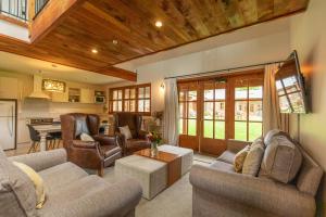 a living room with two couches and a table at Wanaka Homestead Lodge & Cottages in Wanaka