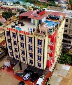 une vue de tête d'un hôtel avec des voitures garées devant lui dans l'établissement Safyad Hotel, à Yaoundé