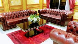a living room with two brown leather couches and a table at Safyad Hotel in Yaoundé