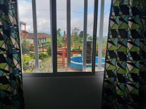 a window with a view of a pool seen through it at Alojamiento Campestre LA PASTORA in Salento