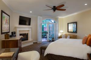 a bedroom with a white bed and a fireplace at Westlake Village Inn in Westlake Village