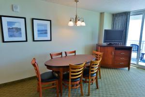 a dining room with a table and chairs and a television at Deluxe Ocean Front Two-Bedroom Condo in Sandy Beach Resort in Myrtle Beach