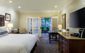 Dormitorio con cama, escritorio y TV en Westlake Village Inn, en Westlake Village