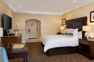 una camera d'albergo con un grande letto e una scrivania di Westlake Village Inn a Westlake Village
