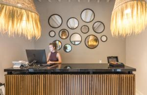 a woman sitting at a desk with a laptop at Casa Quebrada Hotel Boutique in San Miguel de Allende