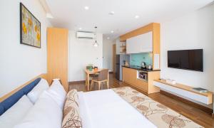 a hotel room with a bed and a kitchen at HSuites Hotel and Apartment in Da Nang