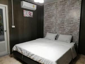 a bed in a room with a brick wall at E2S Place in Nakhon Nayok