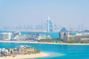 Andaz by Hyatt – Palm Jumeirah في دبي: اطلالة على شاطئ مع مدينة في الخلفية