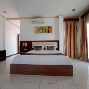 a bedroom with a large bed in a room at Friends Beach Hotel in Kuta Lombok