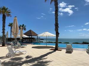 um resort com cadeiras e guarda-sóis e uma piscina em Dolphin View 404 em Mandurah