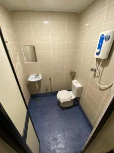 La petite salle de bains est pourvue de toilettes et d'un lavabo. dans l'établissement Sweet Memories Hotel, à Malacca