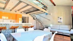 un comedor con mesa y sillas y una escalera en Appart'hôtel Luxe Vieil Antibes 75 m2 avec Parking plages à pieds, en Antibes