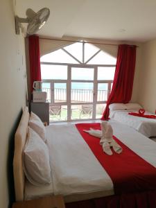 a bedroom with two beds and a large window at Alshumukh guesthouse in Al Ghalīlah