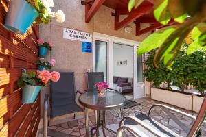 een patio met een tafel en stoelen en een gebouw bij Apartment Carmen in Trogir