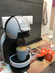 een koffiezetapparaat is het maken van een kopje koffie bij Athens Spirit 49 katechaki apartment in Athene