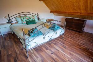 a bedroom with a metal bed and a wooden floor at Landelijk en toch centraal, eigen keuken en veel privacy in Bleiswijk
