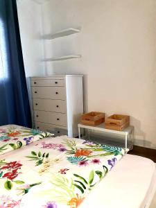 a bedroom with a bed and a dresser with a bedspread with flowers at Casa Lirio in Costa Calma