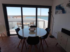 a table and chairs in a room with a view of the ocean at Flamingo Beach House in Santa Luzia +22 photos