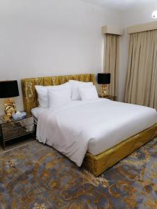 a bedroom with a large white bed and two lamps at Royal Sea View Villa with Private Pool in Ras al Khaimah