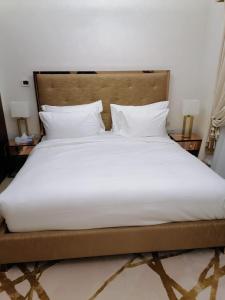 a large bed with white sheets and pillows at Royal Sea View Villa with Private Pool in Ras al Khaimah
