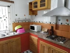 cocina con fogones, fregadero y microondas en Pool Villa Armthong Home en Ban Nong Toei