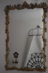 a mirror on a wall with a white curtain at B&B La Loggia Del Castello in Trento