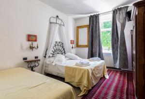 um quarto com 2 camas e uma janela em B&B La Loggia Del Castello em Trento