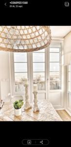 a dining room table with a chandelier and a window at Opaline Baie de somme in Ault