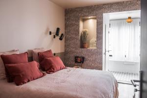 een slaapkamer met een groot bed met rode kussens bij Maison Volver in Arles
