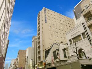 名古屋的住宿－名鐵名古屋錦酒店，一条城市街道上高大的白色建筑