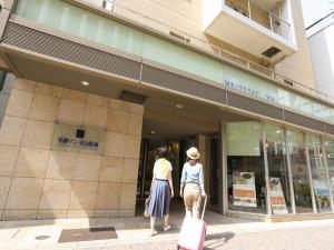 two women are standing outside of a store at Meitetsu Inn Nagoya Nishiki in Nagoya