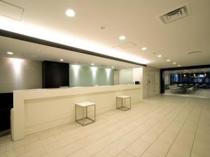 a lobby with a counter and two stools at Meitetsu Inn Nagoya Nishiki in Nagoya