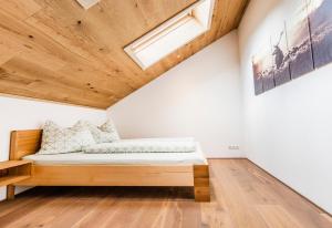 Cama en habitación con techo de madera en Haus Moosbrugger, en Mellau