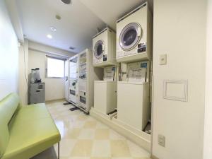 una habitación de hospital con dos lavadoras en la pared en Meitetsu Inn Nagoya Nishiki, en Nagoya
