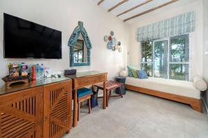 a living room with a tv and a desk and a couch at Samed Villa Resort in Ko Samed