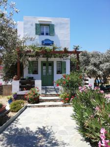 a house with a green door and flowers at Madilides in Platis Yialos Sifnos