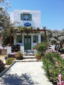 una casa con una puerta verde y flores en Madilides en Platis Yialos Sifnos